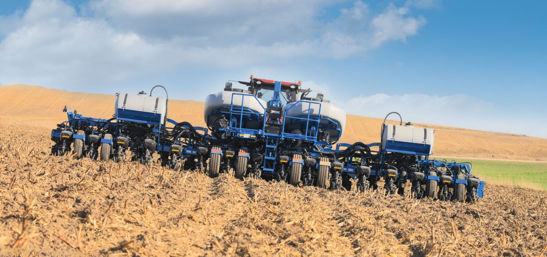 Row units on a Kinze planter working a dusty field