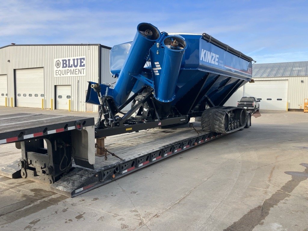 A new Kinze grain cart on a trailer outside the Blue Equipment building