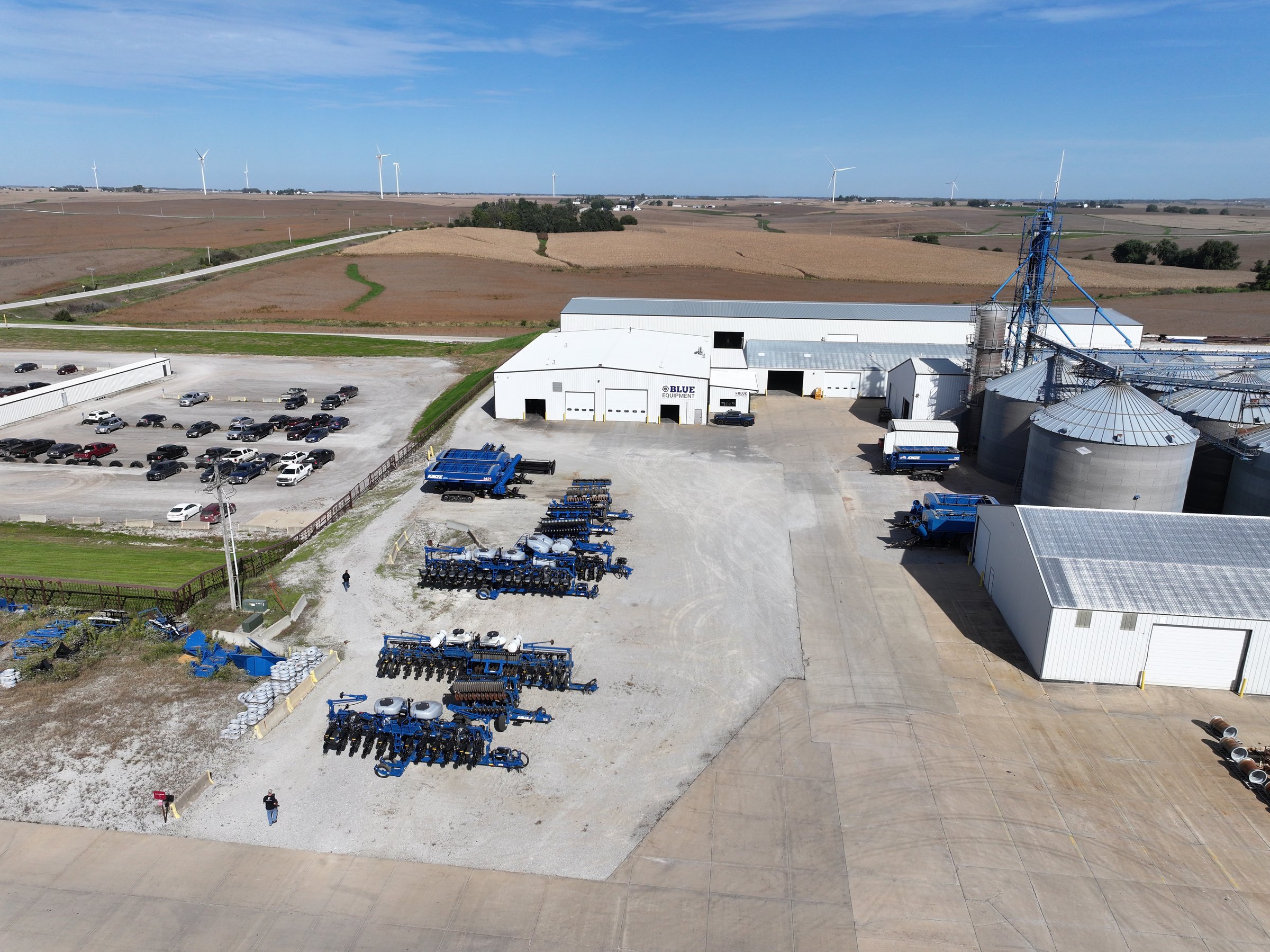 Blue Equipment, Kinze's own dealership, from the air: the shop, the lot and the grain bins beside it, with farm fields beyond